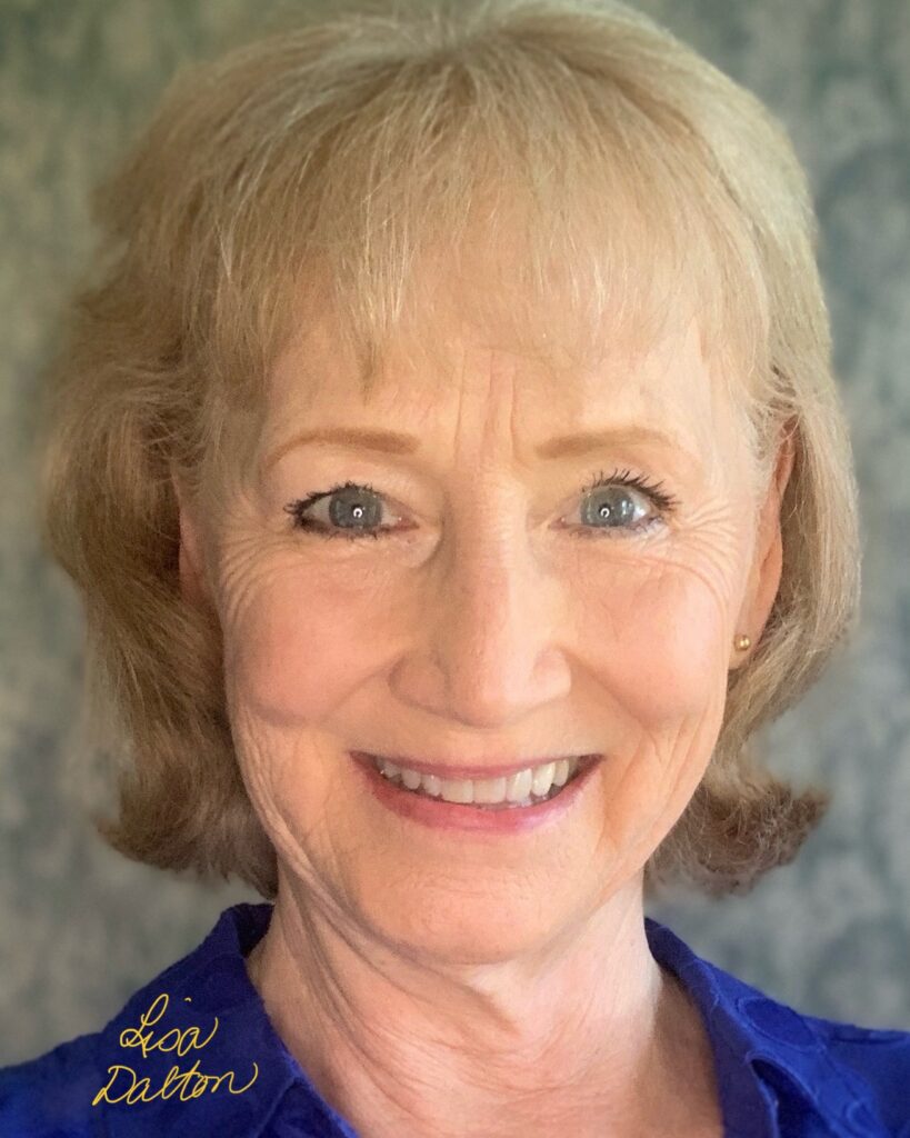 This image reveals the warmth and radiance of Lisa Dalton smiling in a blue blouse with cin-length hair and a little flip.